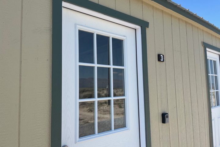 Exterior view of a beige building with a door numbered 3 and a window.