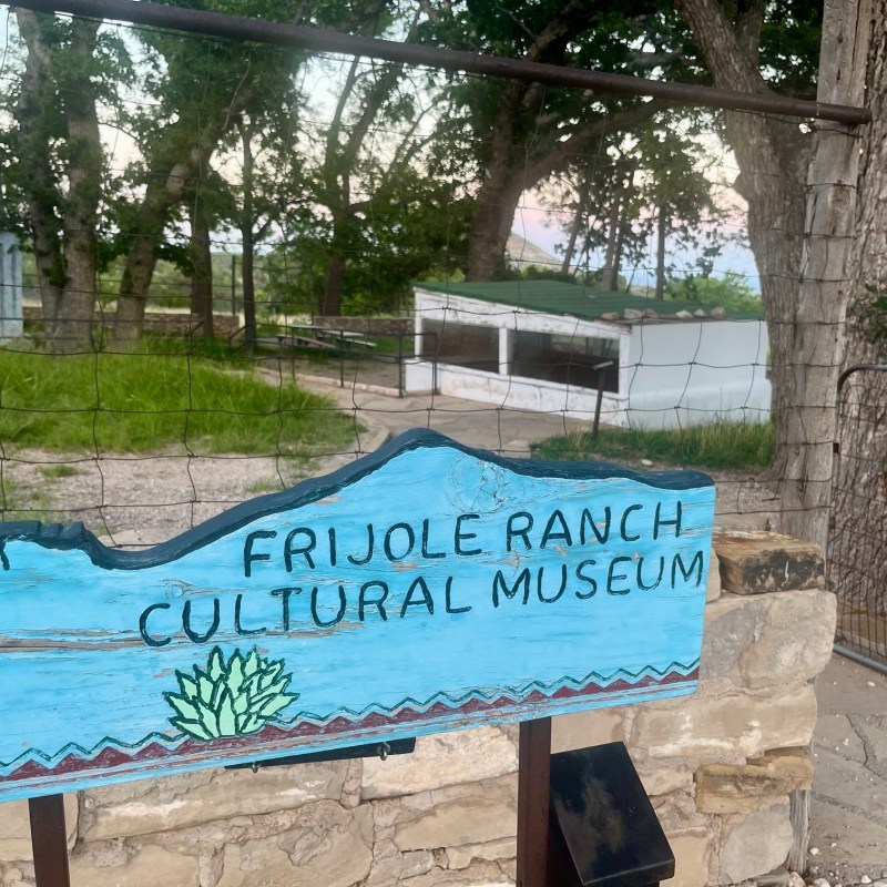 Sign for Frijole Ranch Cultural Museum in a rustic outdoor setting.